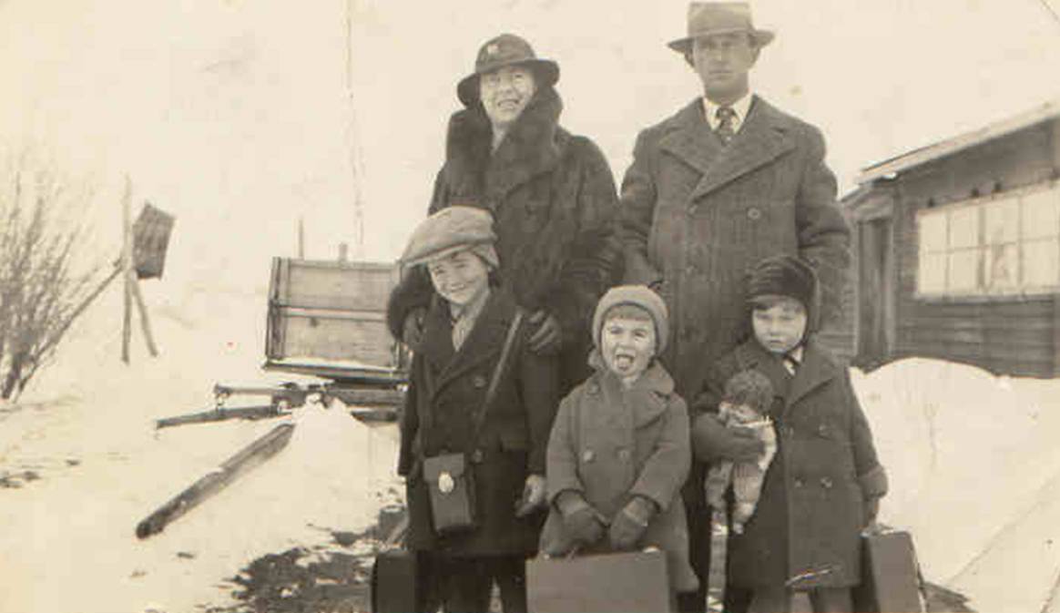 A family posing for a photo in the snow

Description automatically generated